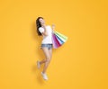 Happy young woman holding shopping bags and talking on the phone